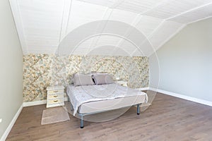 Double bed in interior of the modern bedroom in loft flat in light color style of expensive apartments