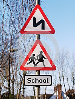 Double bend first to left sign and School children crossing sign