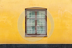 Double casement window on yellow concrete wall photo
