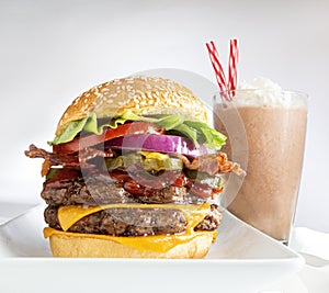 Double cheeseburger with chocolate shake on white background