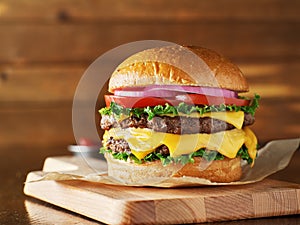 Double cheeseburger with lettuce, tomato, onion, and melted american cheese photo