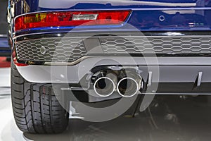 Double chrome exhaust pipe of powerful sport car with grey plastic details