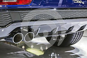 Double chrome exhaust pipe of powerful sport car with grey plastic details