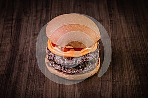 Double craft beef burger with cheddar cheese, caramelized onion.and pepper pout on wood table and rustic background