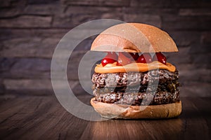 Double craft beef burger with cheddar cheese, caramelized onion.and pepper pout on wood table and rustic background