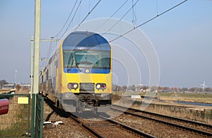 Double decker commuter train at a crossway in Moordrecht
