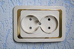 Double electrical outlet on a blue wall