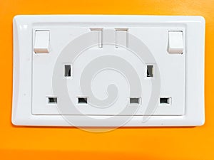 Double electrical outlet on orange colour wall