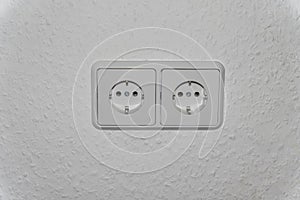 Double electrical socket (European standard) on a light wall.