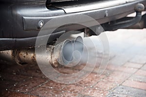 Double exhaust from an older car with diesel engine blows out ga