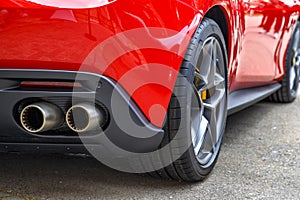 Double exhaust pipes of a modern red sports car.