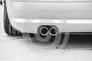 Double exhaust pipes of a modern sports car, black and white