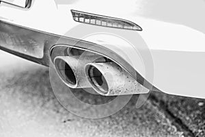 Double exhaust pipes of a modern sports car, black and white