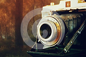 Double exposure and abstract photo of old vintage camera lens over wooden table. selective focus