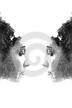 Double exposure of beautiful girl. Face to face. Double exposure of young beautiful girl among the leaves and trees. Portrait of a