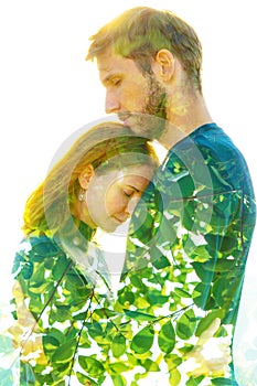 Double exposure of a beautiful young couple combined with bright green leaves