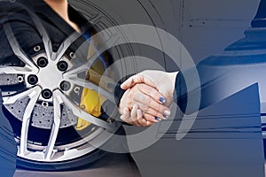 Double exposure of business handshake with wheel car