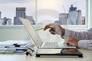 Double exposure of business man hand working on laptop computer on wooden desk with social media network diagram