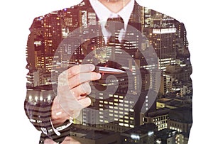 Double exposure of business man holding a pen against city isolated on white background