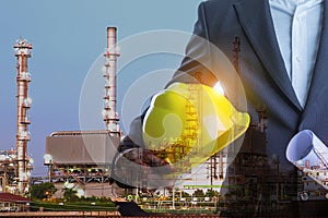 Double exposure of Business man with safety helmet and oil refinery industry plant background