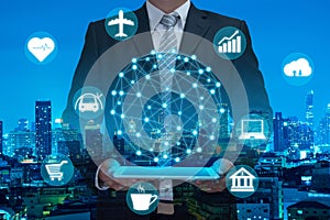 double exposure of business man using telephone or tablet showing digital globe on night modern city building background , intern