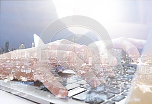 Double exposure of Business man working by laptop and cityscape