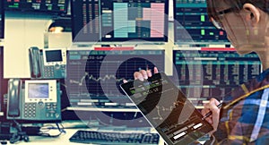 Double exposure of business woman holding tablet for Stock market quotes and chart in monitor computer room with business office