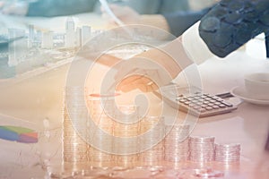 Double exposure of businessman with cityscape, coins and graph