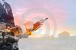 Double Exposure of Businessman and Digital Wireless Tablet with City Building and Skyscraper as concept of Technology business