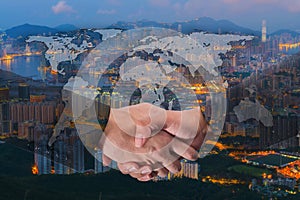 Double Exposure of a businessman handshake on World Global Cartography Globalization with Cityscape Hong Kong Panoramic Night Con