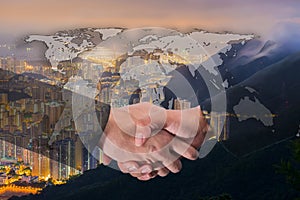 Double Exposure of a businessman handshake on World Global Cartography Globalization with Cityscape Hong Kong Panoramic Night Con