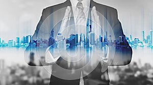 Double exposure businessman holding blue city hologram, real estate business technology