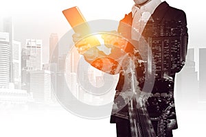 Double exposure of businessman holding tablet with cityscape blurred background.