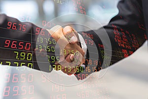 Double exposure of businessman man and businesswoman handshake for partner and price indicator chart from stock market.