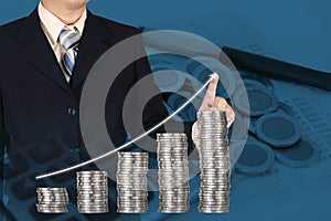 Double exposure businessman touching financial chart with piles