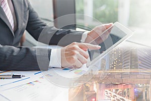 Double exposure businessman using the tablet in office.