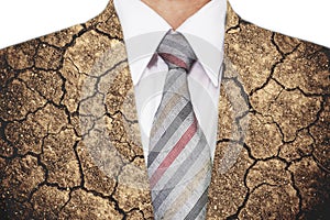 Double exposure, close-up businessman with cracked arid soil ground texture