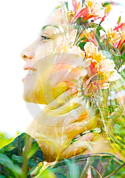 Double exposure close up profile portrait of a young pretty woman interwoven with delicate red and yellow flowers seemingly