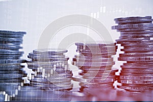 Double exposure of coin stack with stock market screen chart boa