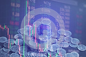 Double exposure of coin stack with stock market screen chart boa