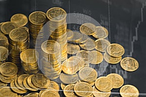 Double exposure of coin stack with stock market screen chart boa