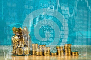 Double exposure of coin stack with stock market screen chart boa