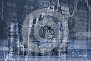 Double exposure of coin stack with stock market screen chart boa