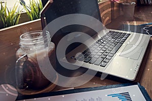 Double exposure of computer on the table inside coffee shop.