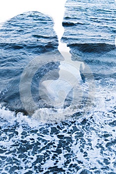 Double exposure with a couple against the backdrop of a raging sea