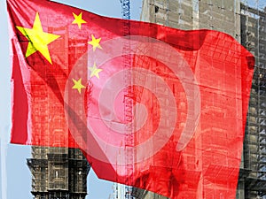 Double exposure creative hologram of unfinished supertall building and Chinese flag. Describe China\'s real estate collapse