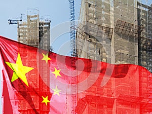 Double exposure creative hologram of unfinished supertall building and Chinese flag. Describe China\'s real estate collapse