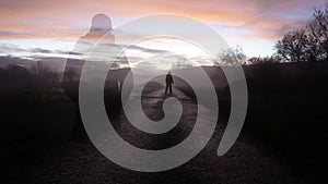 A double exposure of a ghost like transparent mysterious figure, with a man silhouetted against the sunset on a lonely spooky