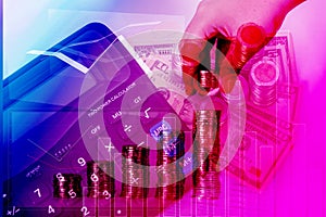 Double exposure of hand put money coins to piles of coins arranged as a graph with coins currency and calculator