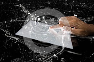 Double exposure hand using tablet and city on night